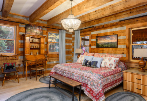 Cozy Cabin Update to the Master Bedroom complete with log beams and hardwood flooring