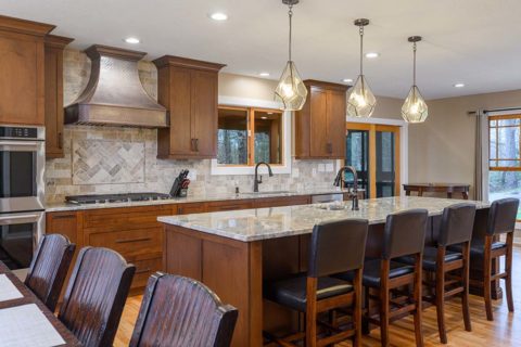 Pendant lights over a long center island complements this kitchen style