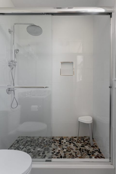 Tiled shower with stone flooring in Whispering Pines, North Carolina.