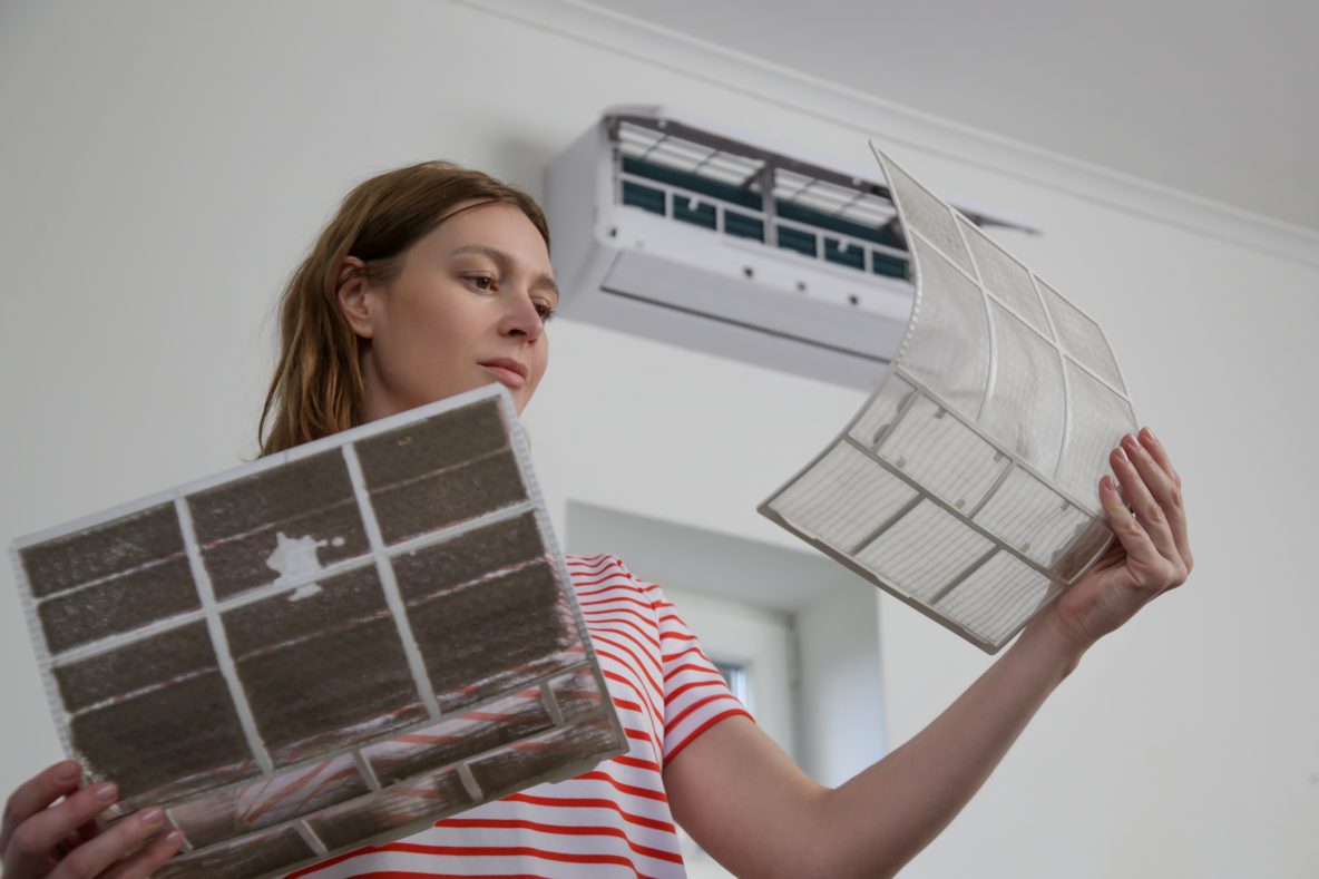 Woman improving air quality with new AC filter.