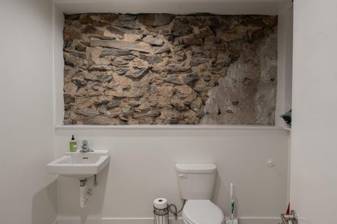 Bathroom with exposed rock wall in Black Mountain, North Carolina.